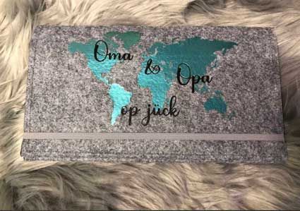 Auf einer pelzigen Oberfläche steht eine Schachtel mit einer Weltkarte darauf.