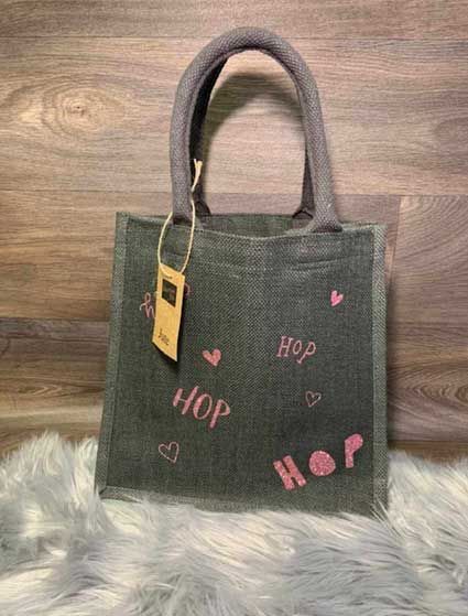 Eine kleine Einkaufstasche liegt auf einer Plüschdecke auf einem Holztisch.