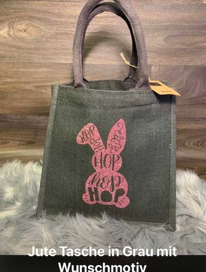 Eine graue Einkaufstasche mit einem rosa Häschen darauf.