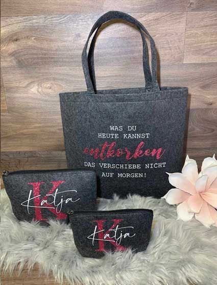 Eine Einkaufstasche und zwei Kosmetiktaschen liegen auf einer flauschigen Decke.