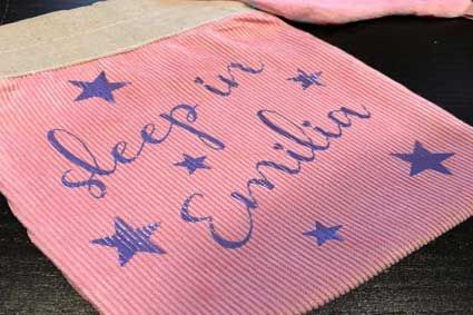 Eine rosa Decke mit der aufgestickten Aufschrift „Schlaf in Emilia“.