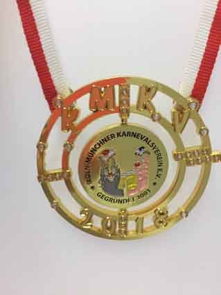 Eine Person trägt eine Goldmedaille mit einem roten Band um den Hals.