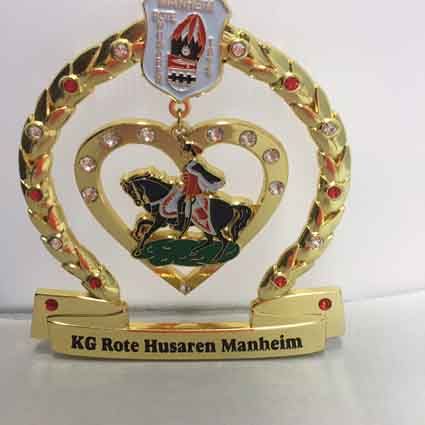 Eine goldene Trophäe mit einem Mann auf einem Pferd in einem herzförmigen Rahmen.