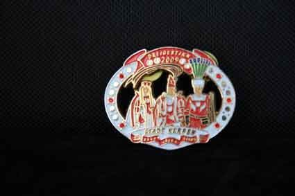 Eine Gürtelschnalle mit der Abbildung eines Hufeisens und Menschen darauf.