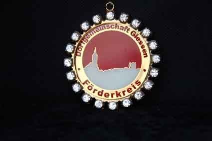 Eine Goldmedaille mit der Abbildung einer Burg auf schwarzem Hintergrund.