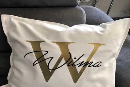 Auf einem Sofa liegt ein weißes Kissen mit dem Buchstaben W darauf.
