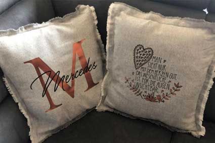 Auf einem Sofa liegen zwei Kissen.