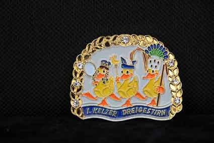 Eine Gürtelschnalle mit drei Enten auf schwarzem Hintergrund.