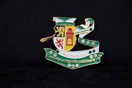 Eine Brosche mit einem Wappen auf schwarzem Hintergrund.