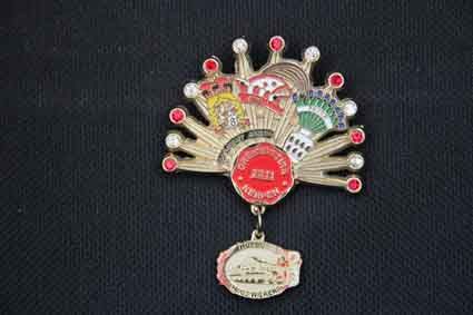 Eine Brosche in Form eines Pfaus mit einer daran befestigten Medaille.