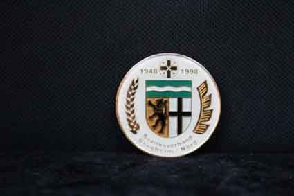 Auf einem Tisch liegt eine Münze mit einem Wappen darauf.