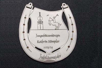 Ein weißes Hufeisen mit einem Bild eines Pferdes darauf