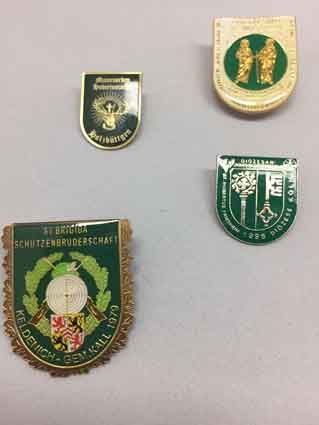 Eine Gruppe von Abzeichen liegt übereinander auf einem Tisch.