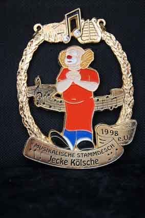 Eine Anstecknadel mit einem Clown und Musiknoten darauf.