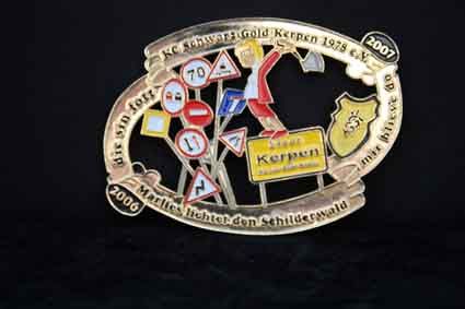 Eine Brosche mit einer Reihe von Zeichen auf schwarzem Hintergrund.