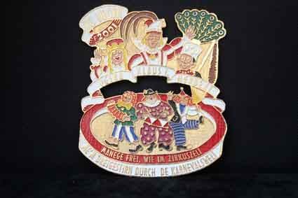 Auf schwarzem Hintergrund befindet sich eine Anstecknadel mit einer Gruppe Clowns.