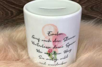 Ein weißes Sparschwein mit einem rosa Ballon darauf