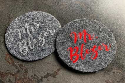 Auf einem Tisch liegen zwei Untersetzer mit der Aufschrift „Mr. und Mrs.“.