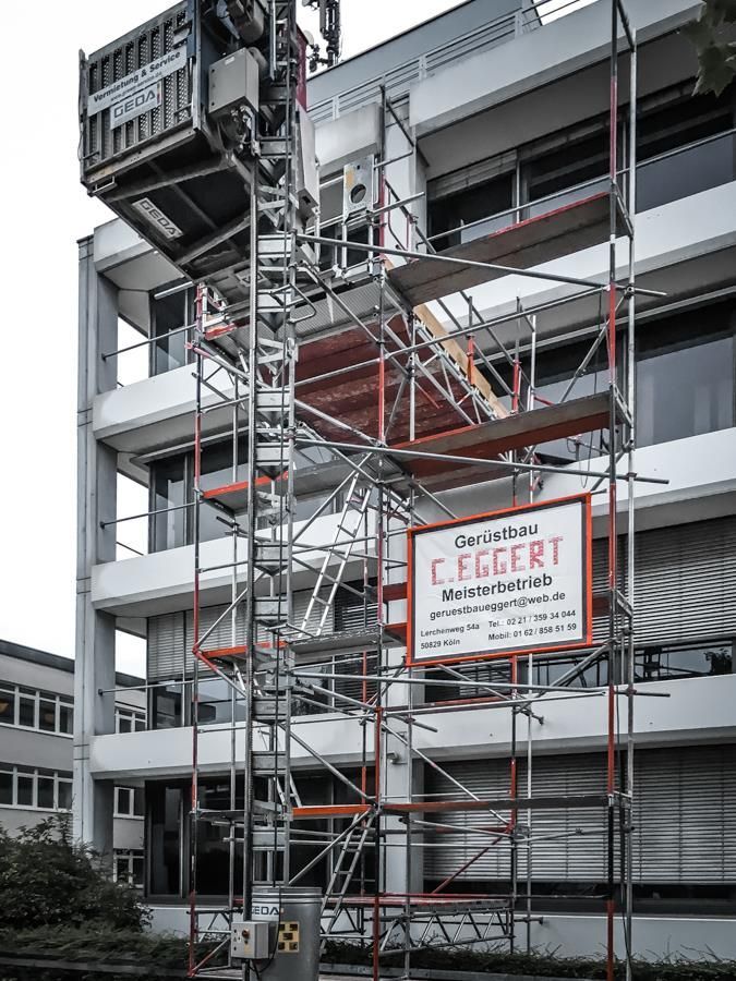 Mit Gerüst und Kran wird ein Gebäude errichtet.