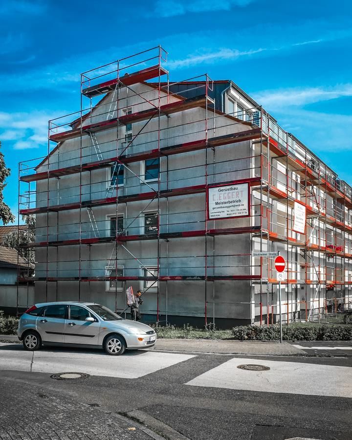 Ein Auto ist vor einem im Bau befindlichen Gebäude geparkt.