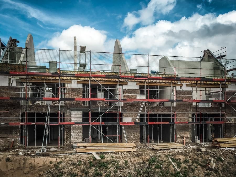Ein im Bau befindliches Gebäude mit Gerüst und einem blauen Himmel im Hintergrund.
