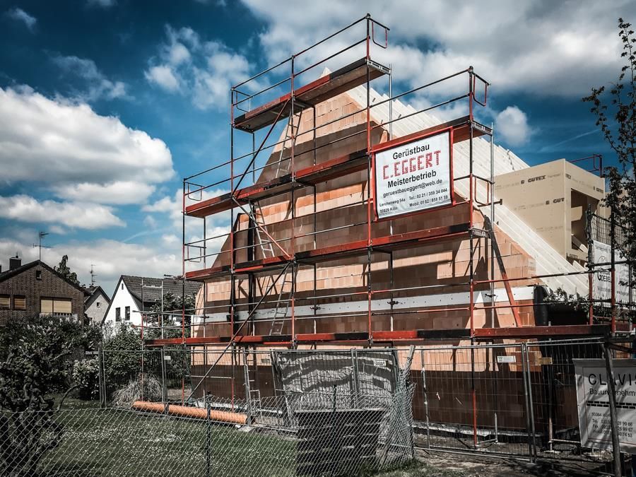 Es wird ein Gebäude errichtet, das von einem Gerüst umgeben ist.