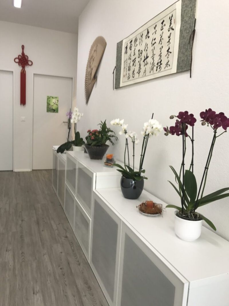 Ein Flur mit Blumen und einem Gemälde an der Wand