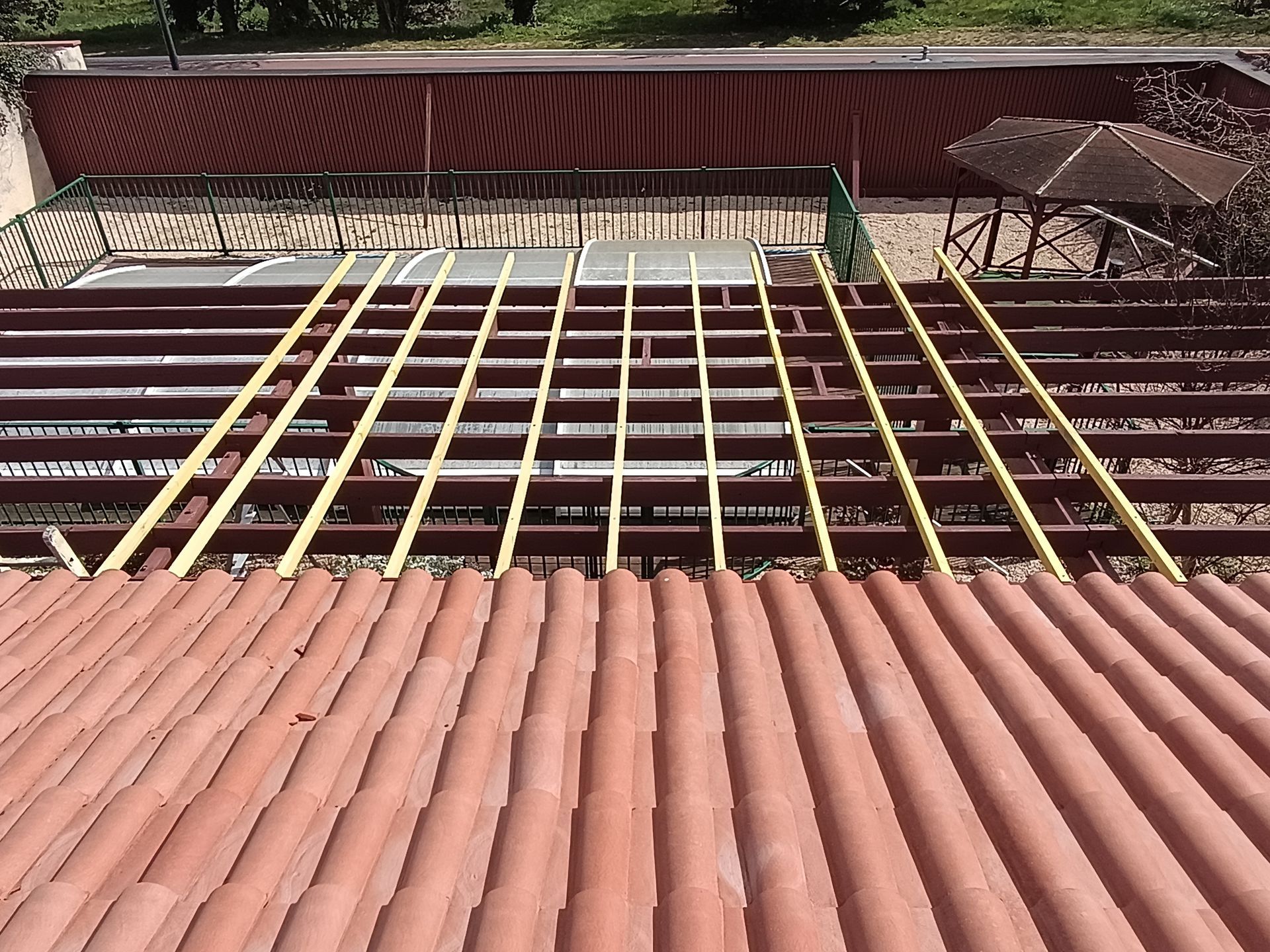 Toiture en tuiles de terre cuite, charpente en bois et écran sous toiture.