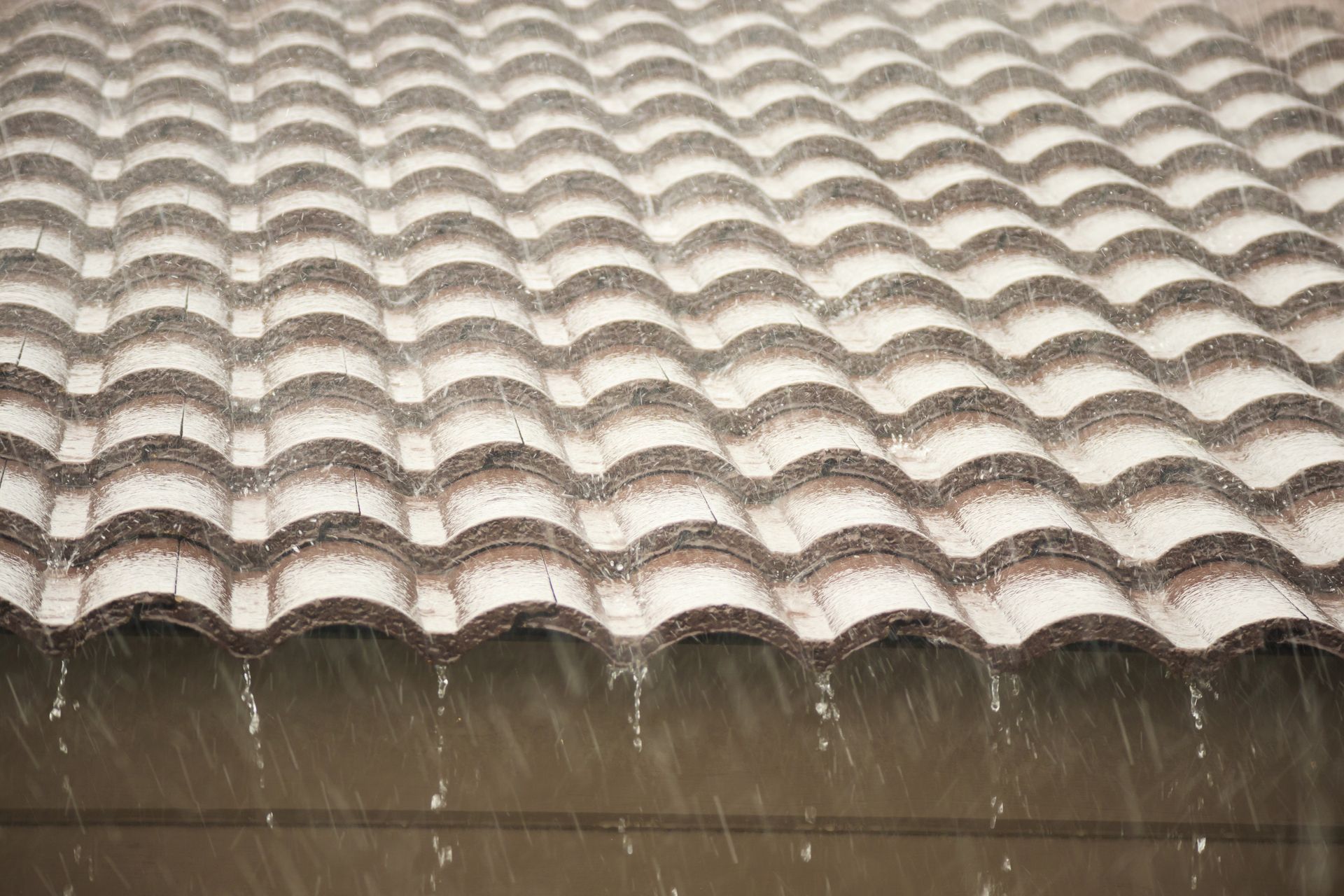 Pluie tombant d'un toit en tuiles.