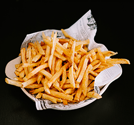 Tigela de batatas fritas douradas com cobertura polvilhada.