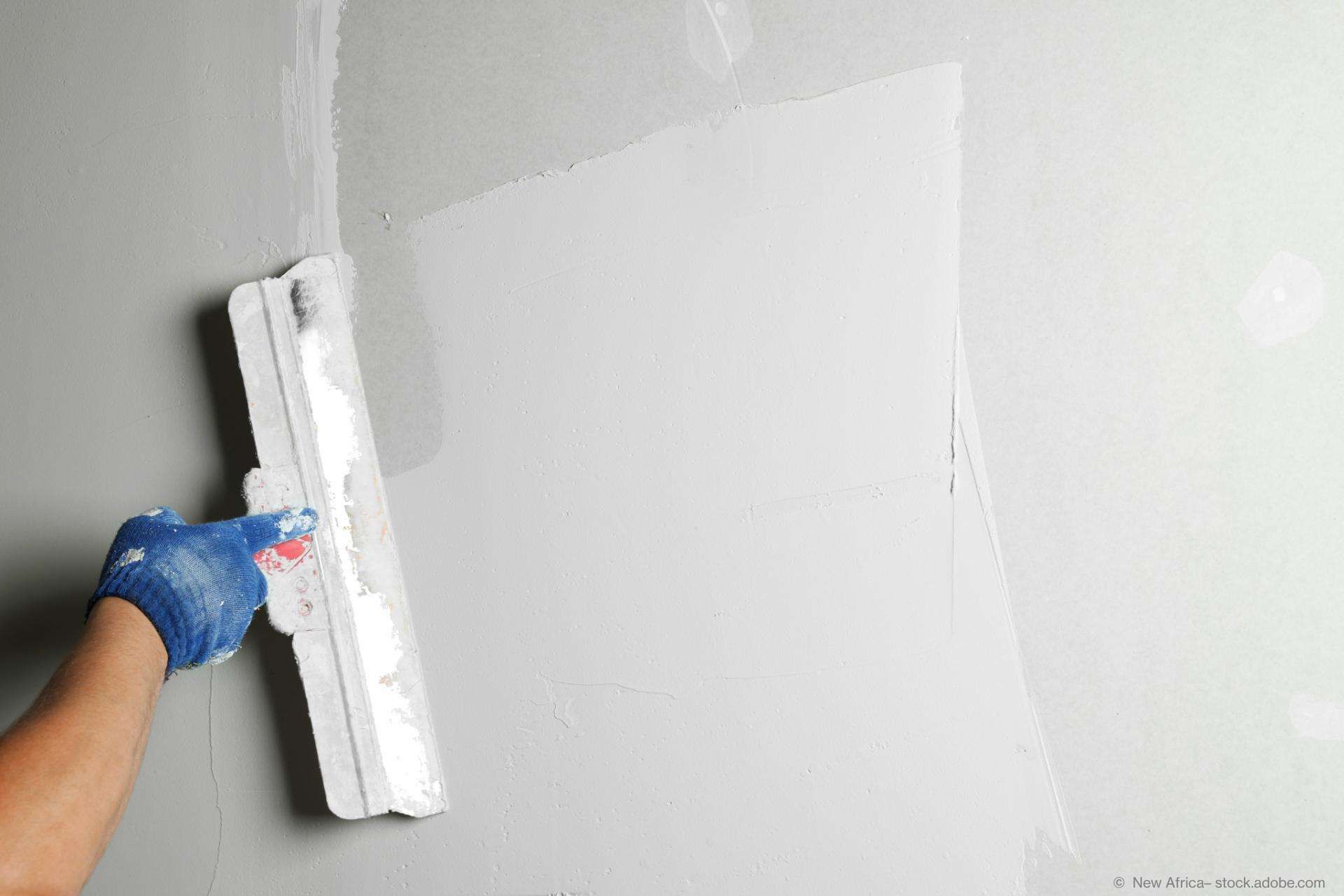 Eine Person verspachtelt eine Wand