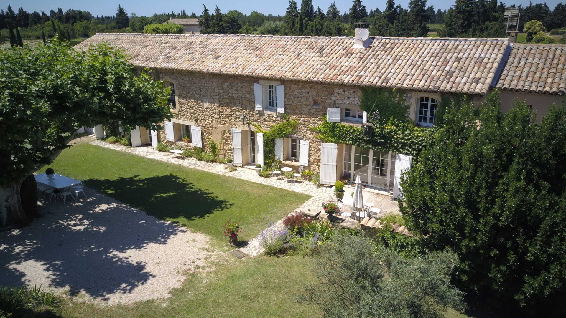 Villa sur deux niveaux avec piscine et colonnes à l'extérieur.