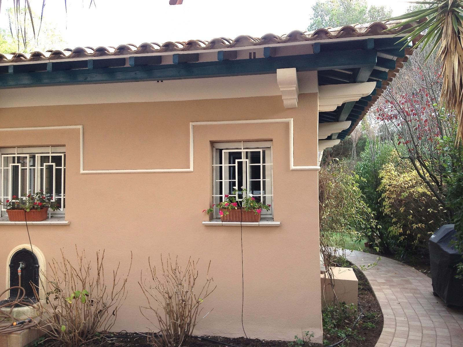 Façade de la villa ocre et détail de moulure extérieure rénovée