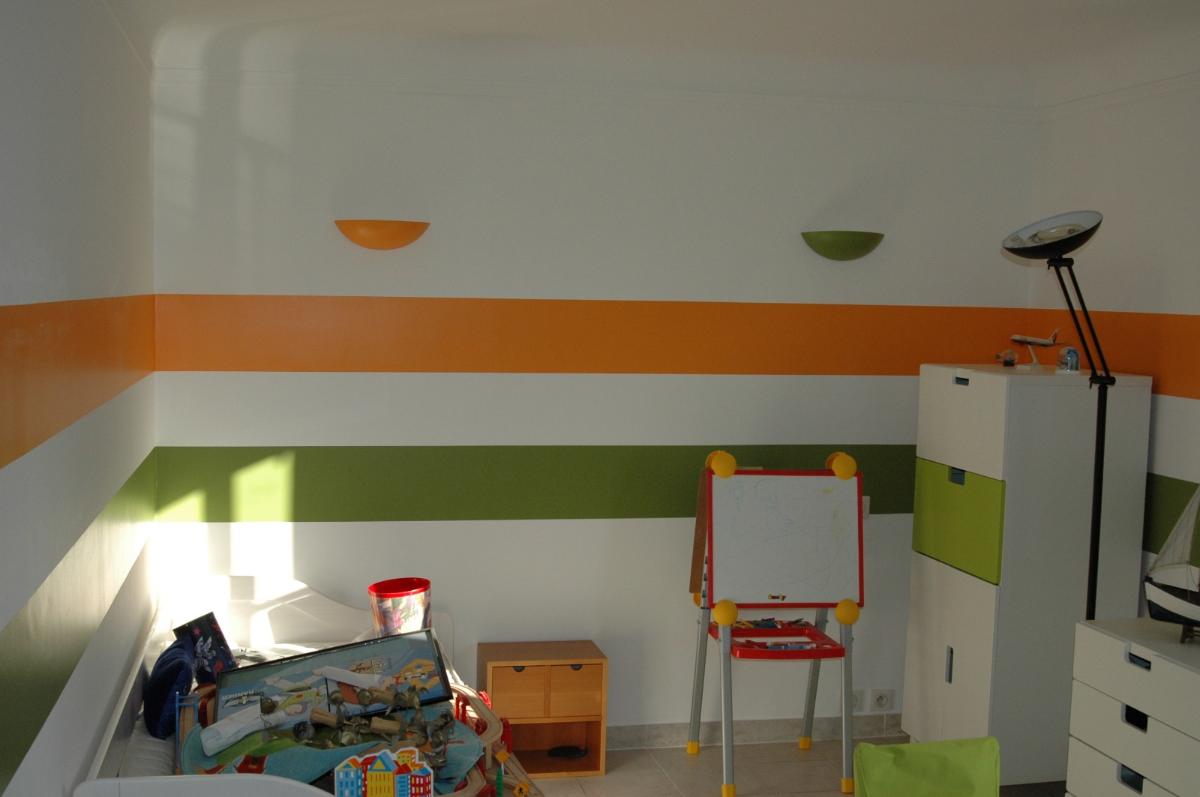 Intérieur de chambre pour enfant avec motif mural rayé peint orange et vert