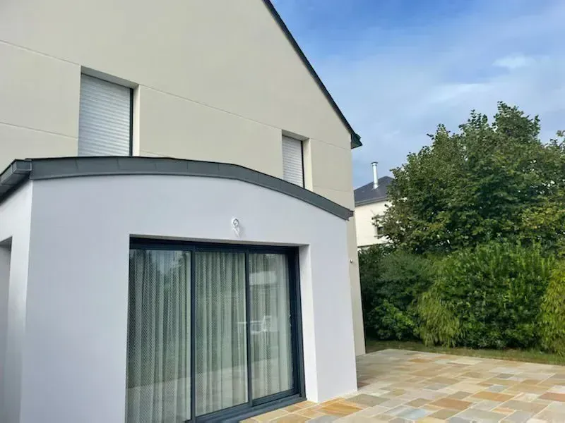 Ravalement d'une façade de maison avec une extension