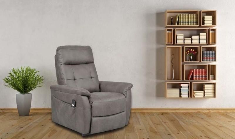 Fauteuil gris à côté d'une bibliothèque