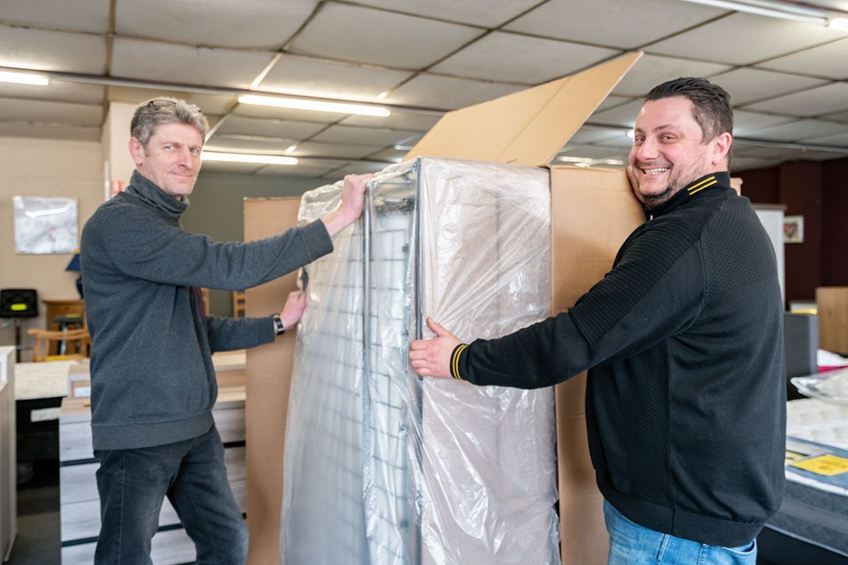 Deux hommes qui déballent un lit