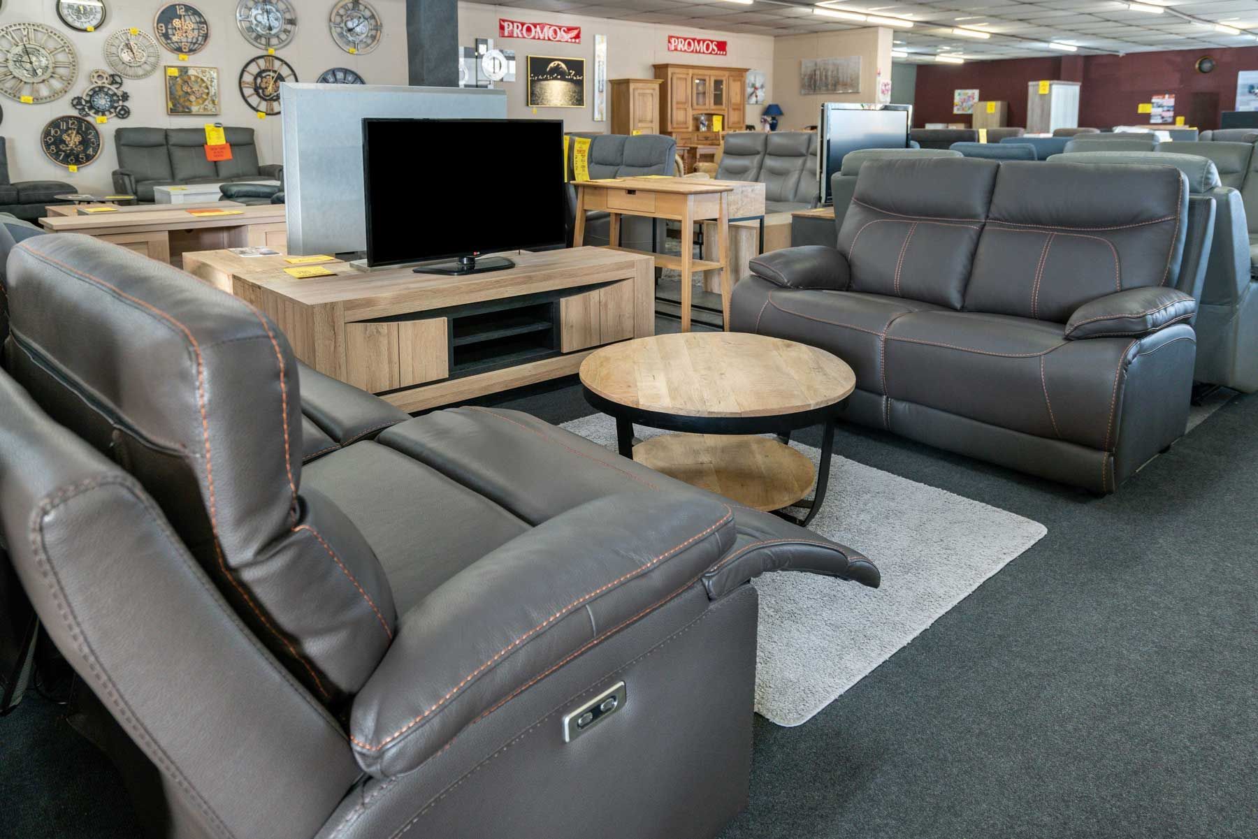 Meuble de télé avec deux sofas face à face séparés par une table basse circulaire