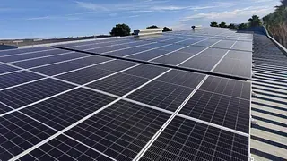 Paneles solares cubriendo un tejado en un día soleado. Cielo azul de fondo.