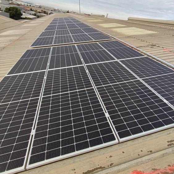 Paneles solares instalados en un techo de metal bajo un cielo soleado.