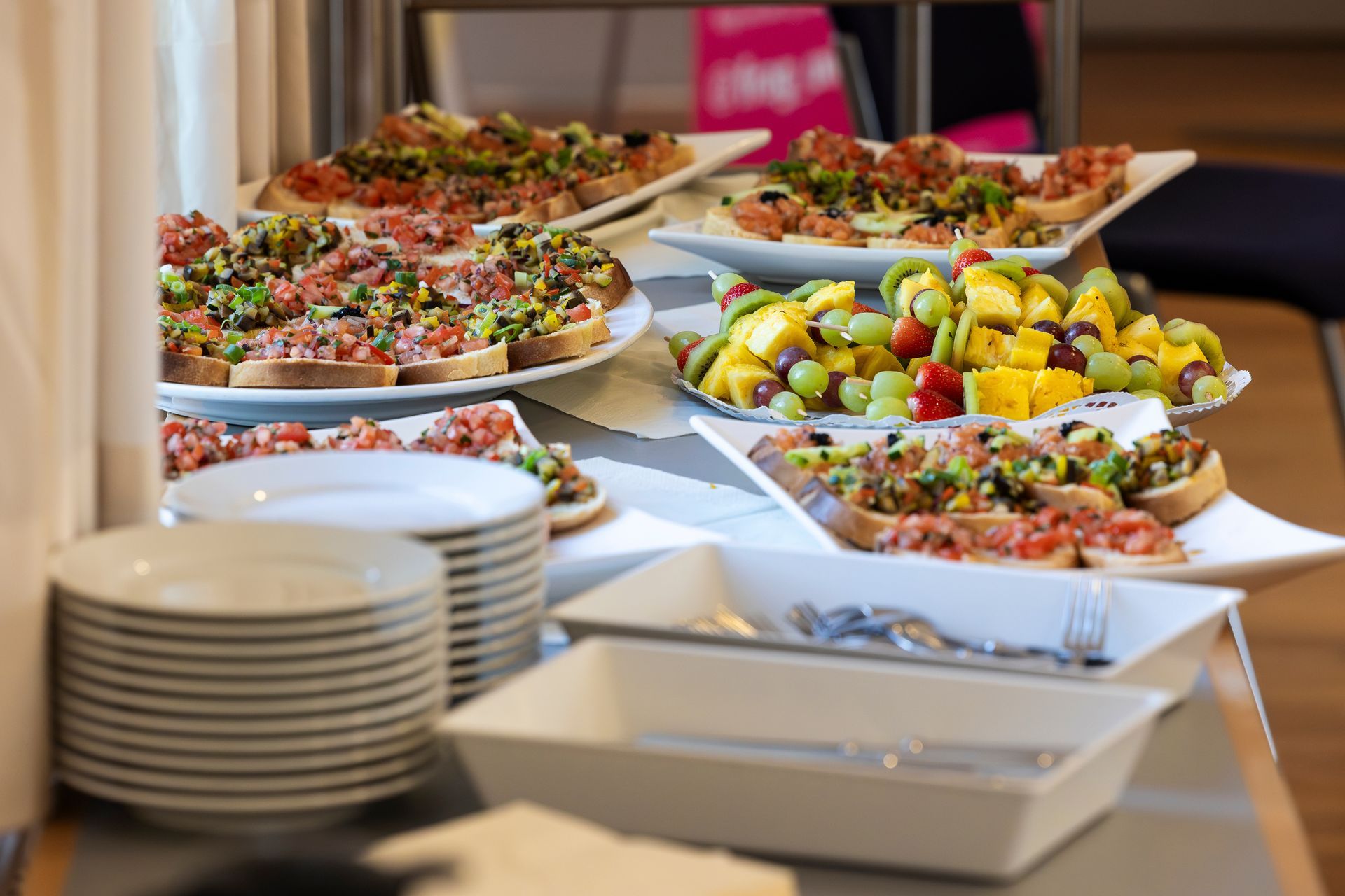 Buffet avec assiettes, plateaux de salades, fruits et amuse-gueules disposés pour le service