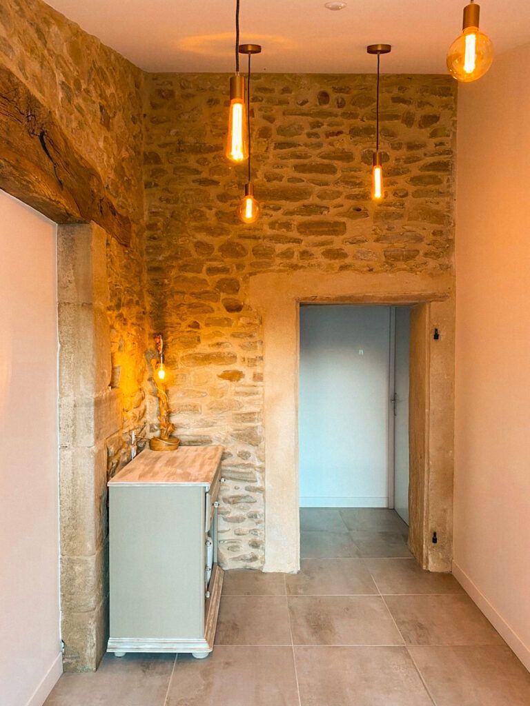 Couloir étroit en pierre avec des suspensions lumineuses