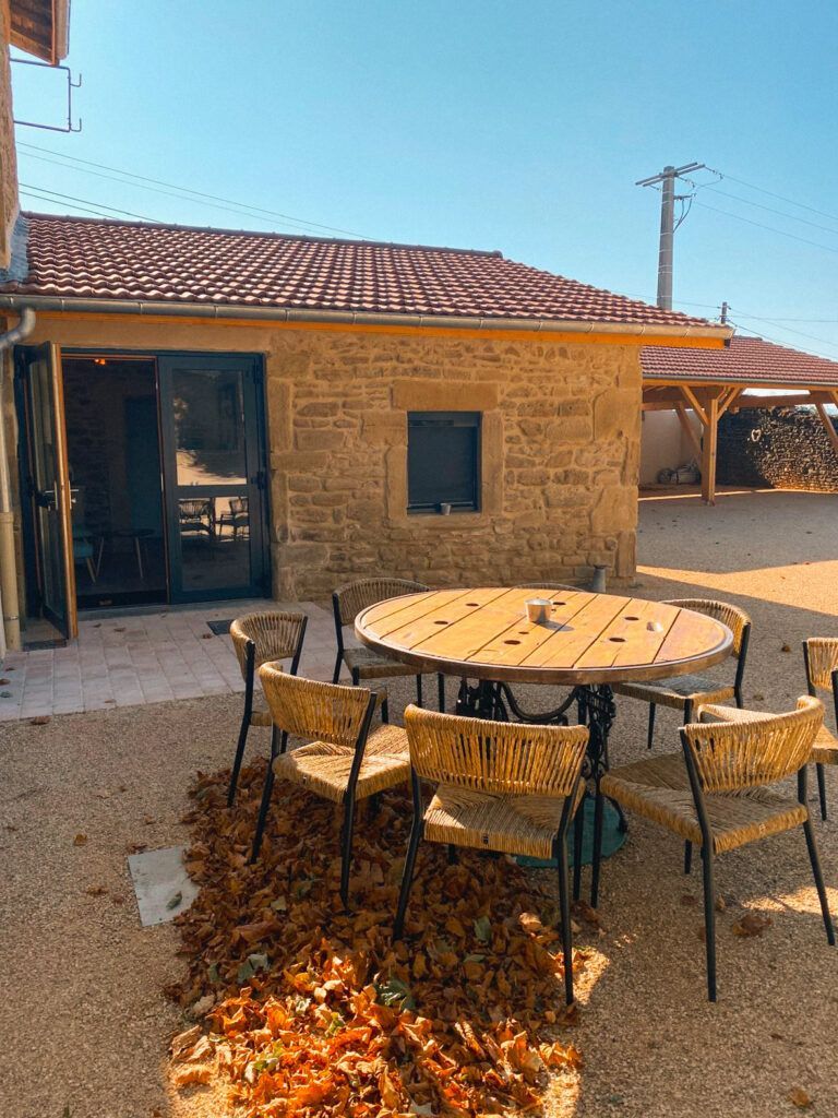 Patio rustique avec table ronde et chaises à l'extérieur d'une maison en pierre