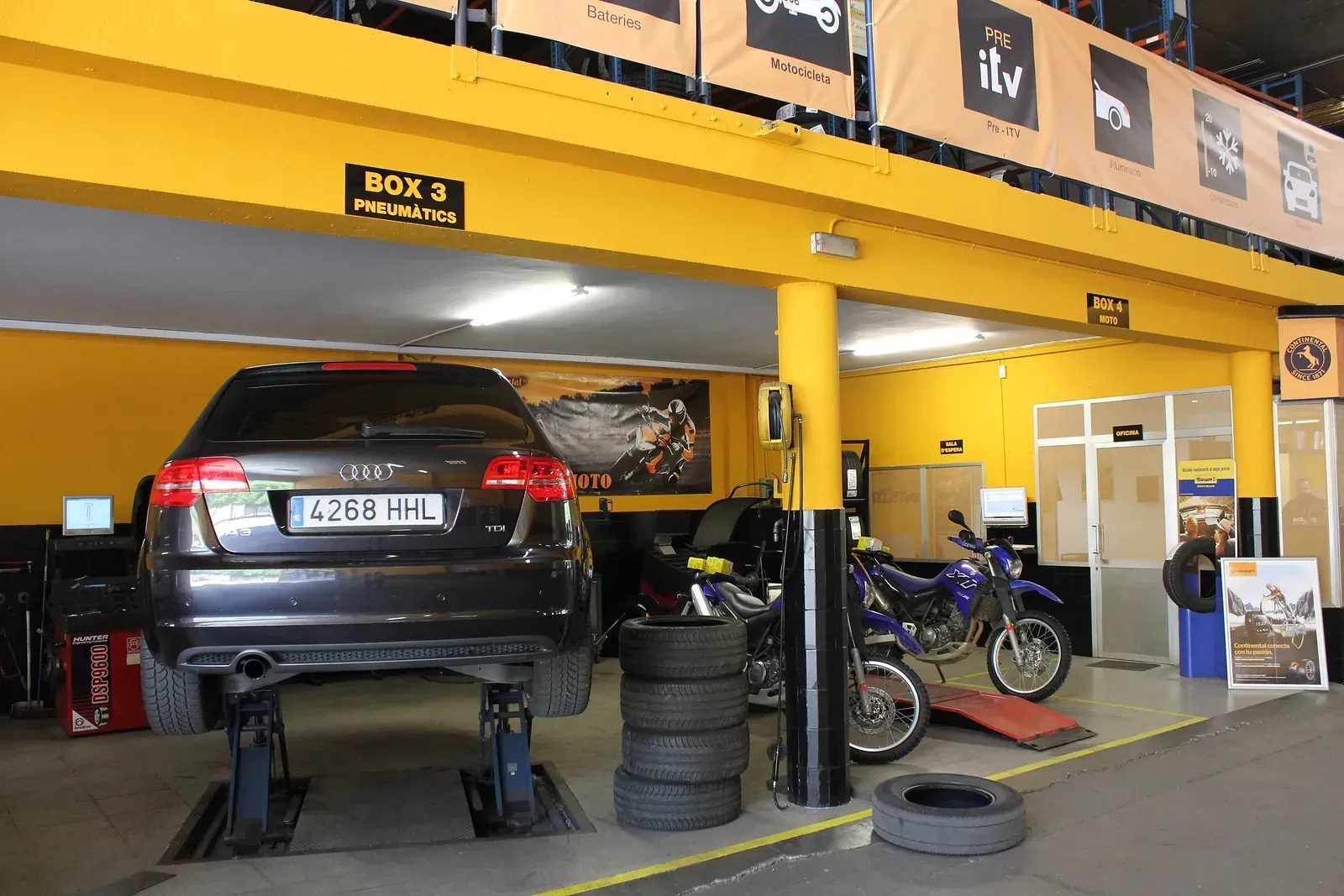 Un cotxe està assegut en un elevador en un garatge.