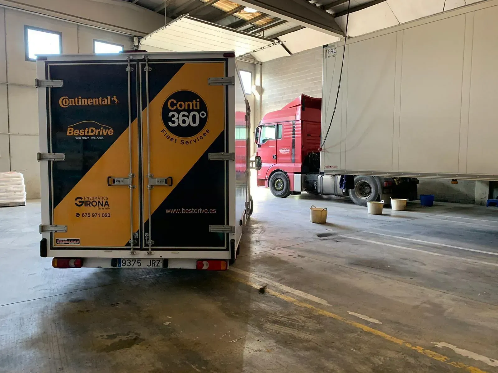 Un camió està aparcat en un magatzem amb la porta oberta