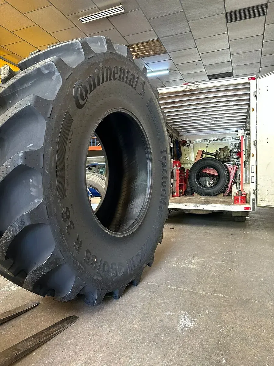 Un pneumàtic gran és en un garatge al costat d'un remolc.