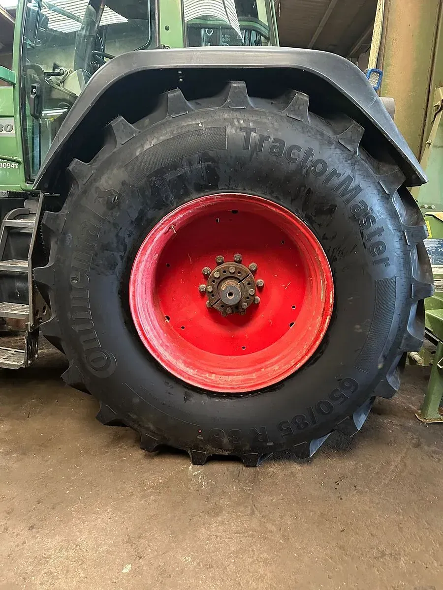 Un primer pla d'un pneumàtic d'un tractor en un garatge.