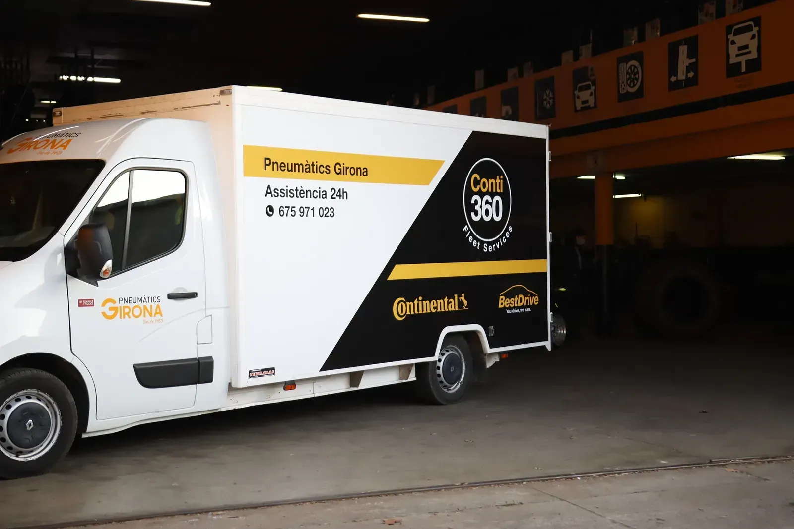 Una furgoneta blanca i negra està aparcada en un garatge.