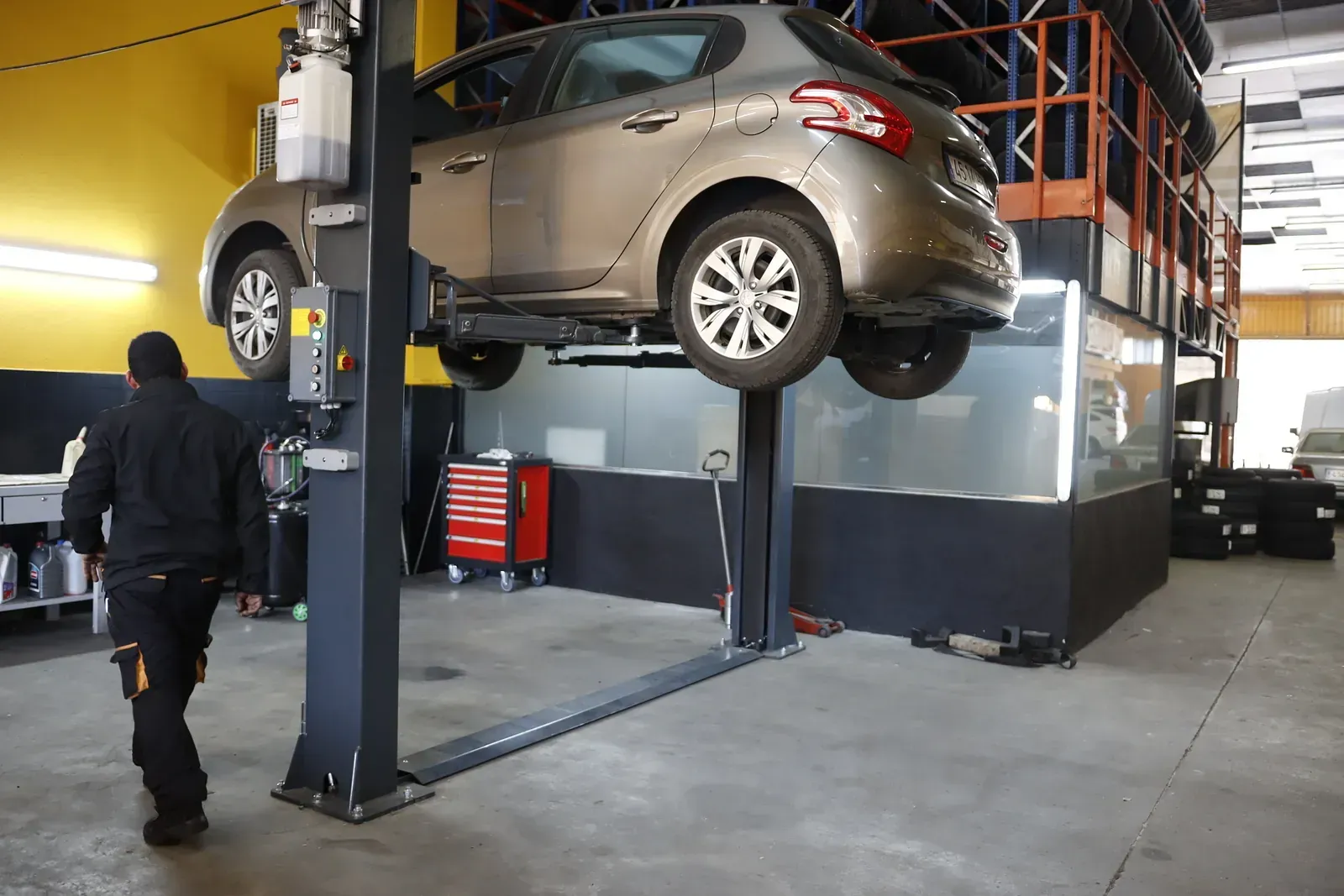 Un cotxe està assegut en un elevador en un garatge.