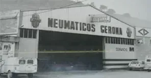 Una foto en blanc i negre d'un edifici que diu neumàtics gerona